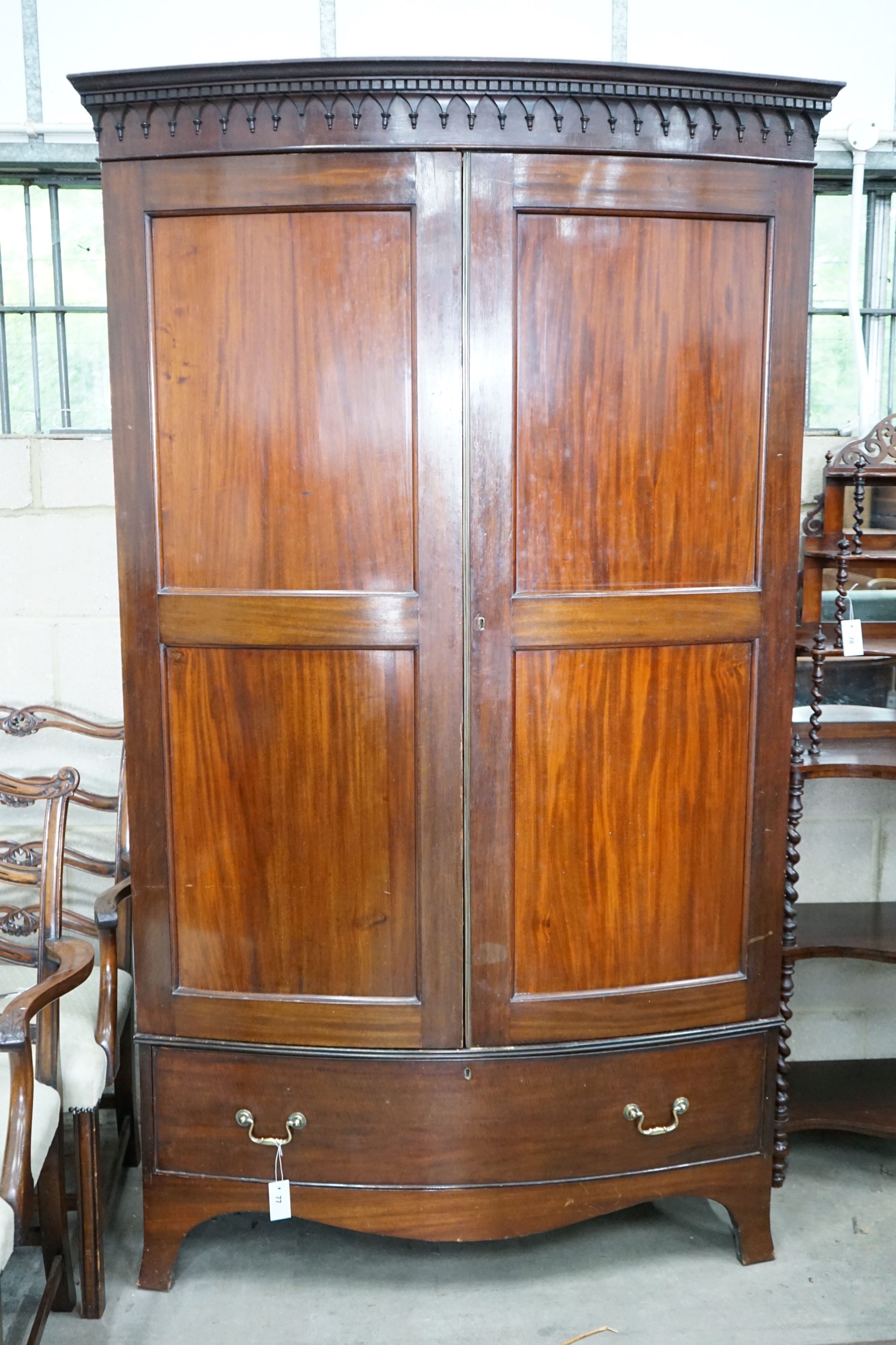 An early 20th century George III style mahogany bowfront wardrobe, with hanging space and one long drawer, length 122cm, depth 64cm, height 206cm